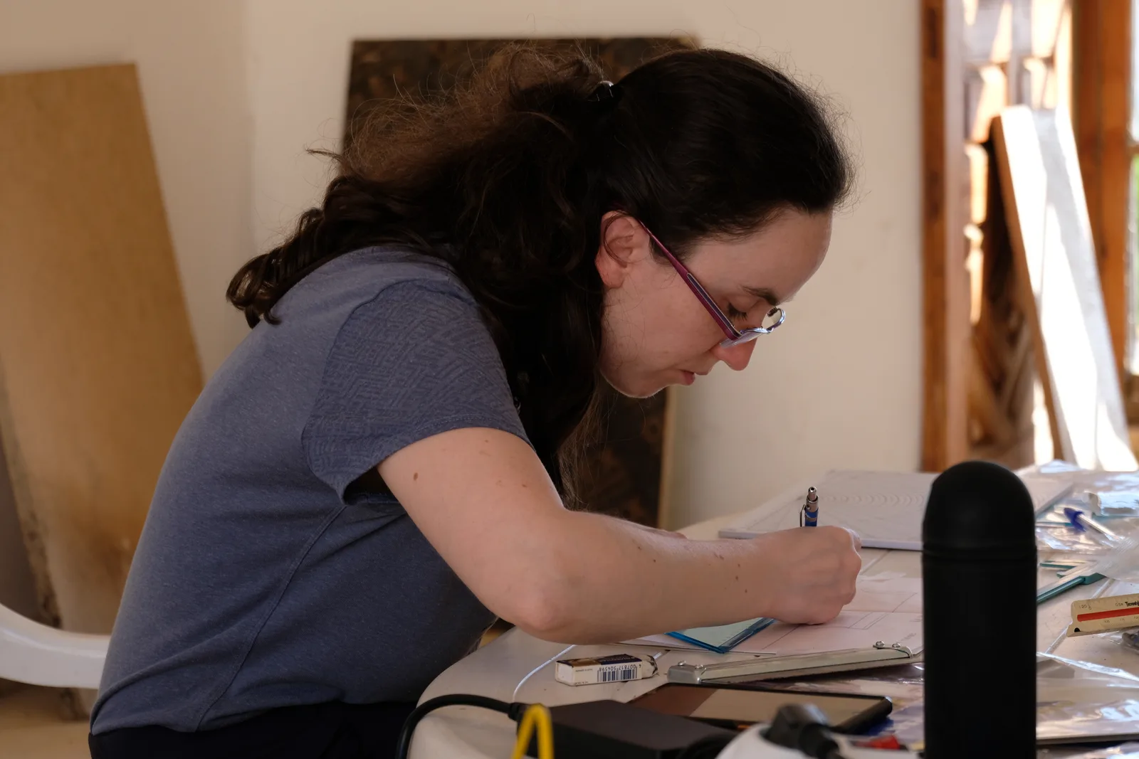 Archaeologist sketching a ceramic fragment at the field lab